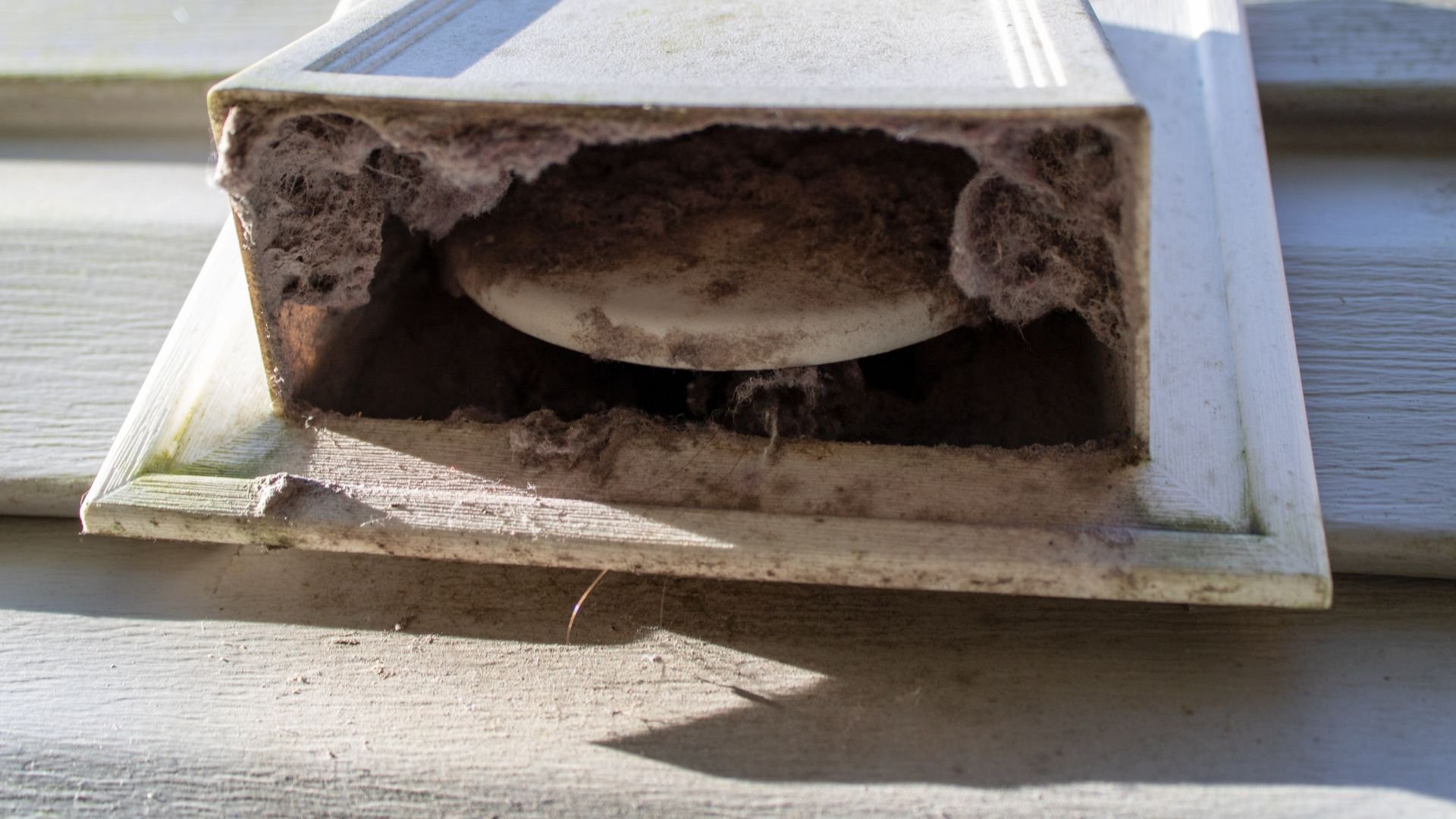 Dirty, damaged electrical outlet covered in dust and debris