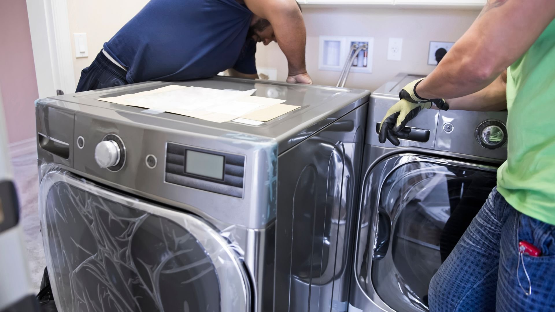 Technicians repairing or installing modern washing machine and dryer