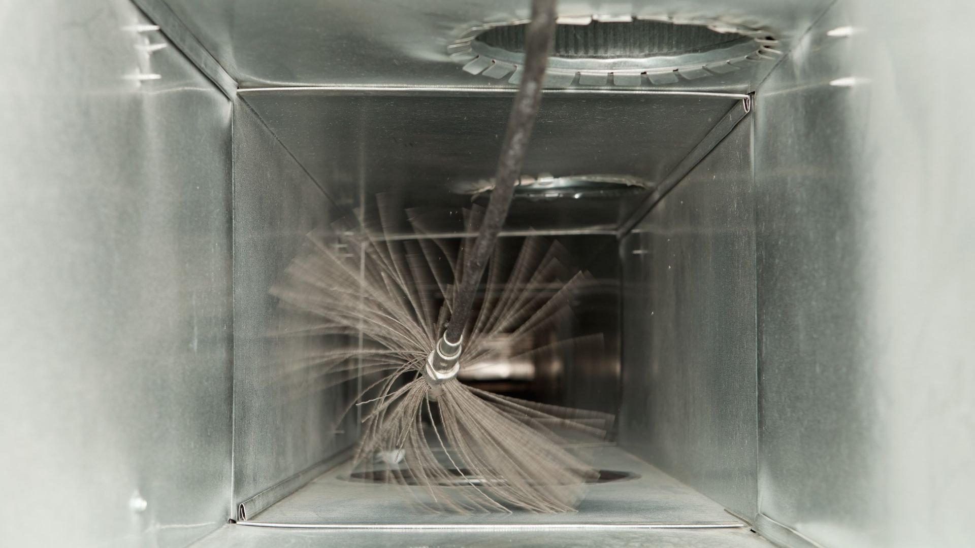Water spraying inside a metallic box creating a radial splash pattern