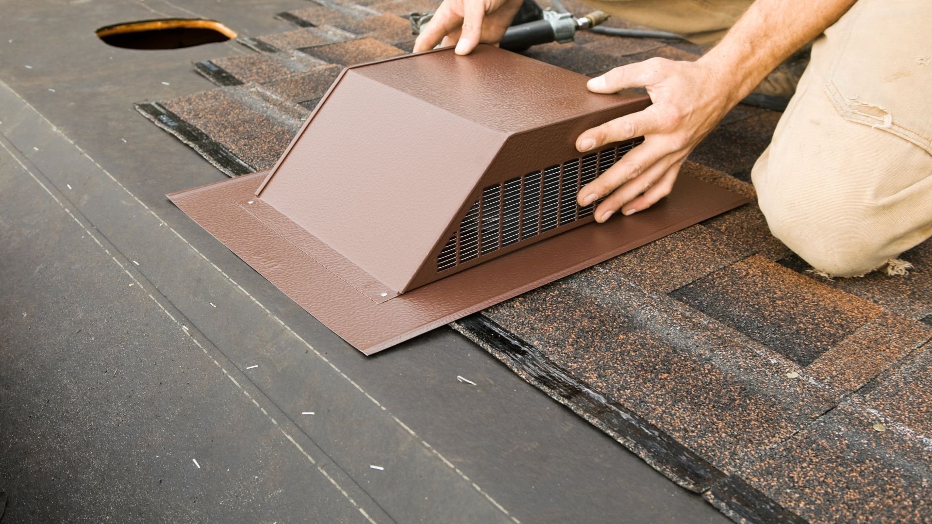Installing a brown roof vent on shingle roofing with hands positioning device
